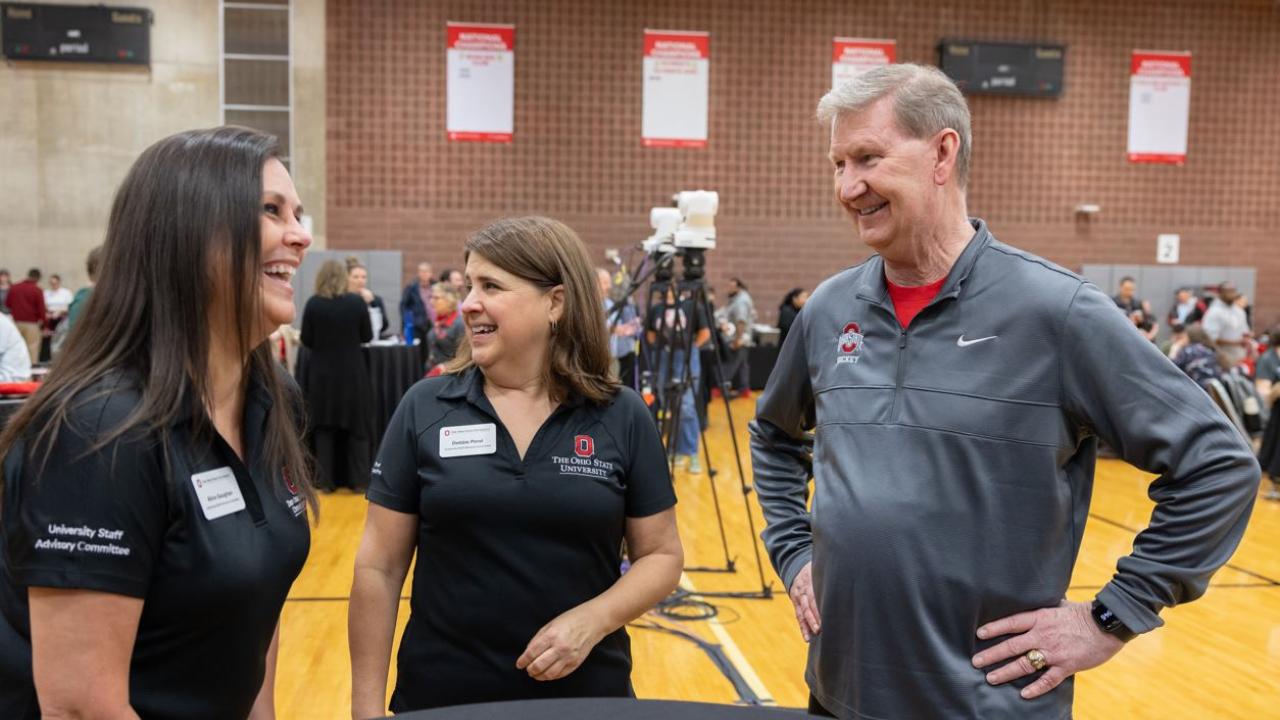 Two staff members with the university president at a wellness event